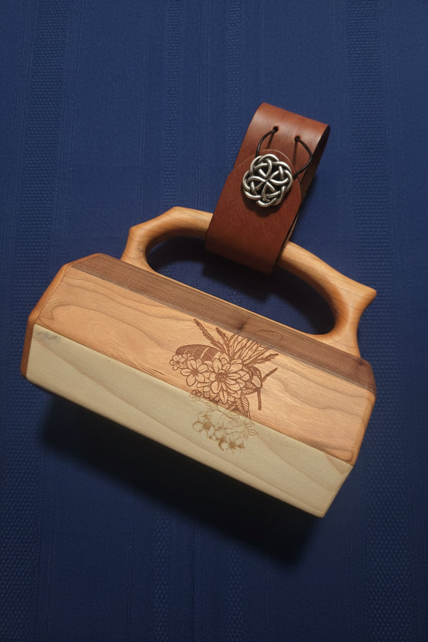 Wooden tankard with leather mug strap attached to handle, showing engraved bee and floral design